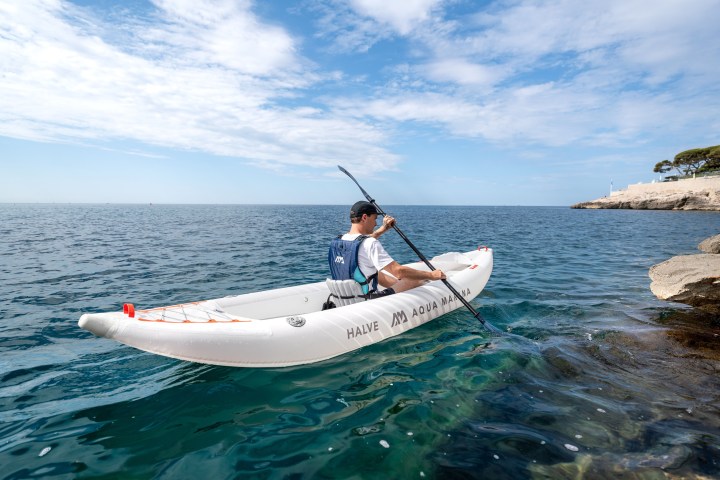 a man riding on the back of a boat in a body of water