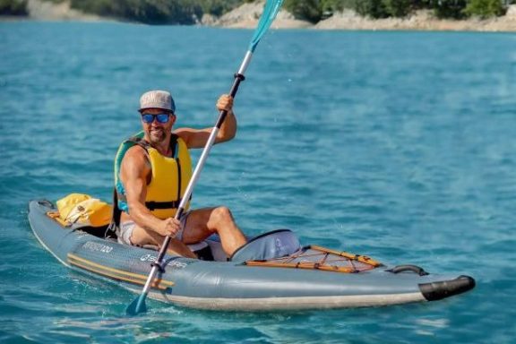 a man riding on the back of a boat in a body of water