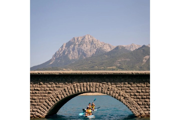 a bridge over a body of water with a mountain in the background