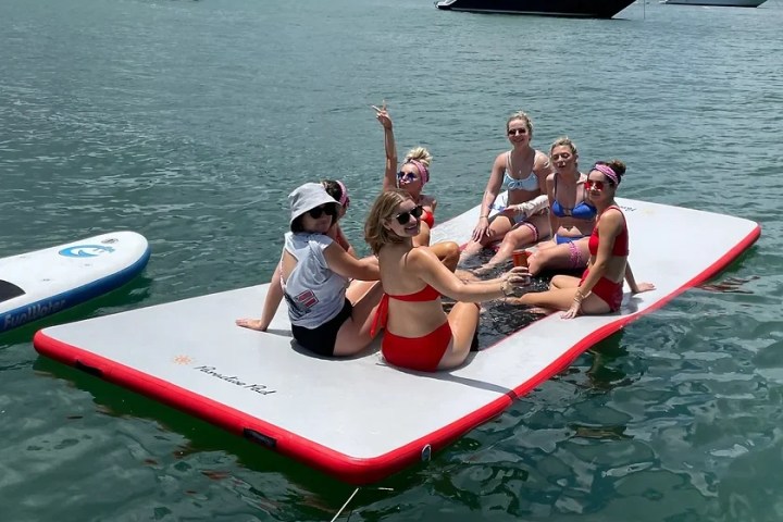 a group of people riding on the back of a boat in the water